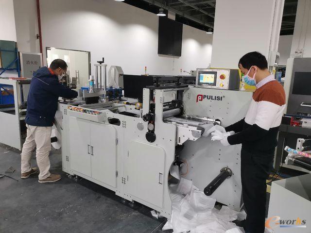 普理司工作人员正在调试口罩机